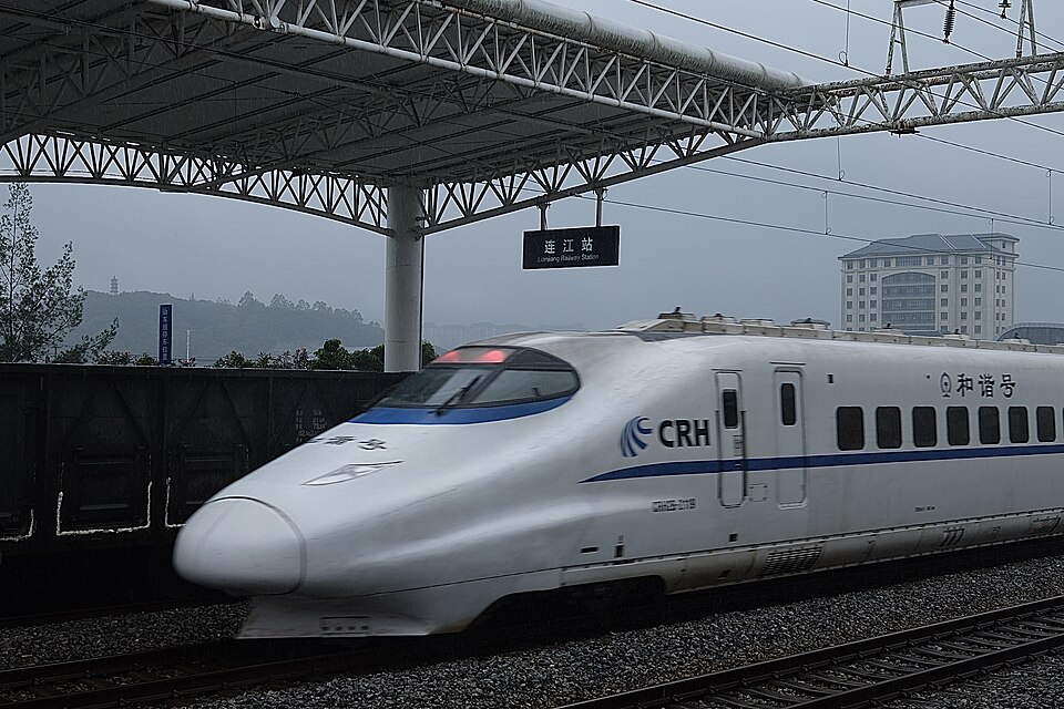 CRH2 high-speed train traveling past a railway station in Fujian, China