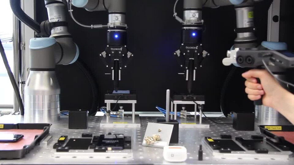 Technician performs quality inspection on smartphones in an electronics production environment