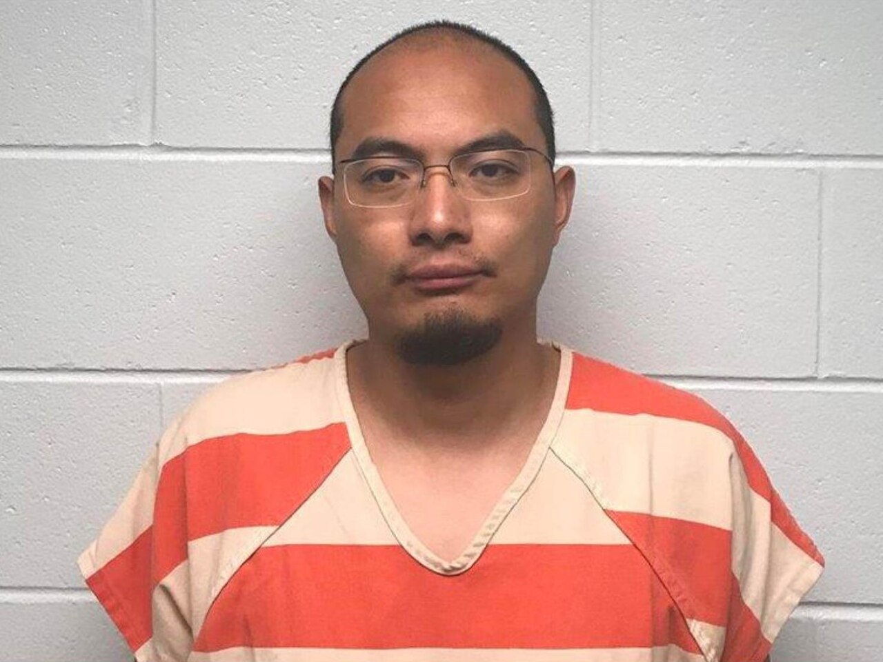 Official identification photograph of Yanjun Xu wearing an orange-and-white jail uniform